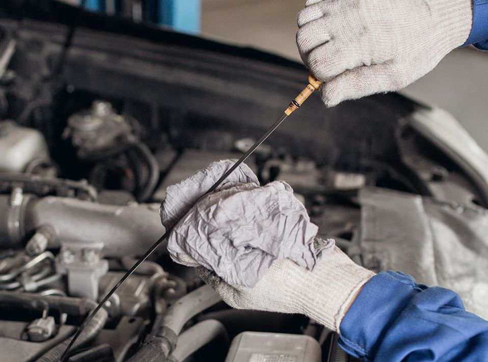 Mechnic cleaning the engine oil stick - Car Servicing Glasgow